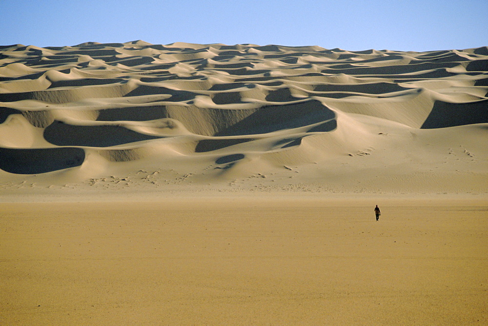 Sahara Desert with lone figure in foreground, Amguid, Algeria, Africa 