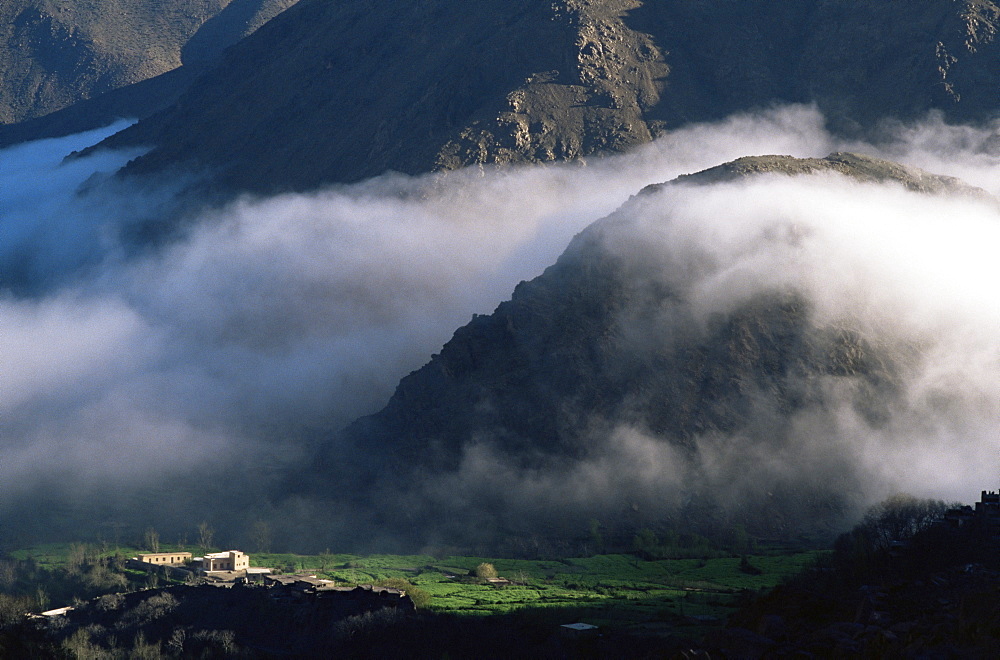 Local school below mist rising in valley of the High Atlas mountains, Morocco, North Africa, Africa