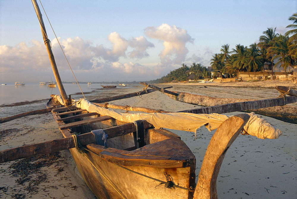 Canoe pulled up onto beach at dusk, Bamburi Beach, near Mombasa, Kenya, Africa 