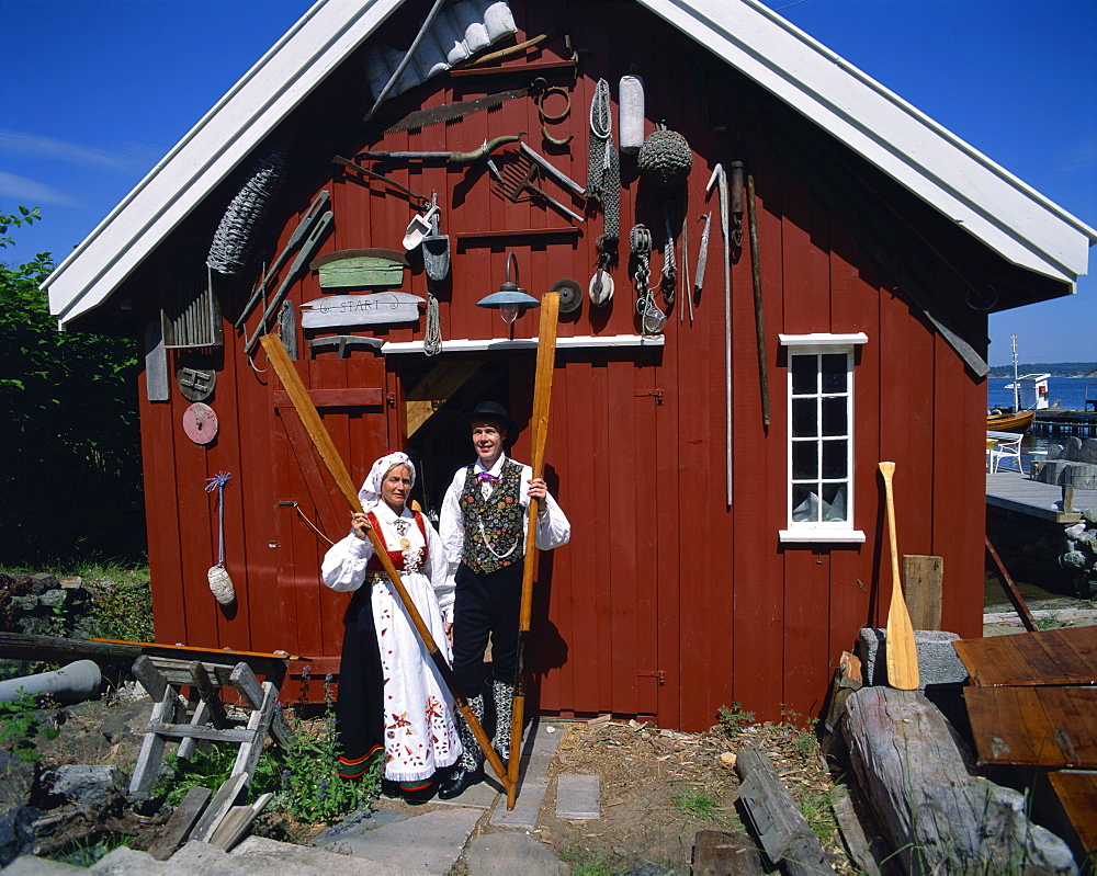 Portrait of couple in the national costume in front of wooden barn, Arendal, Norway, Scandinavia, Europe