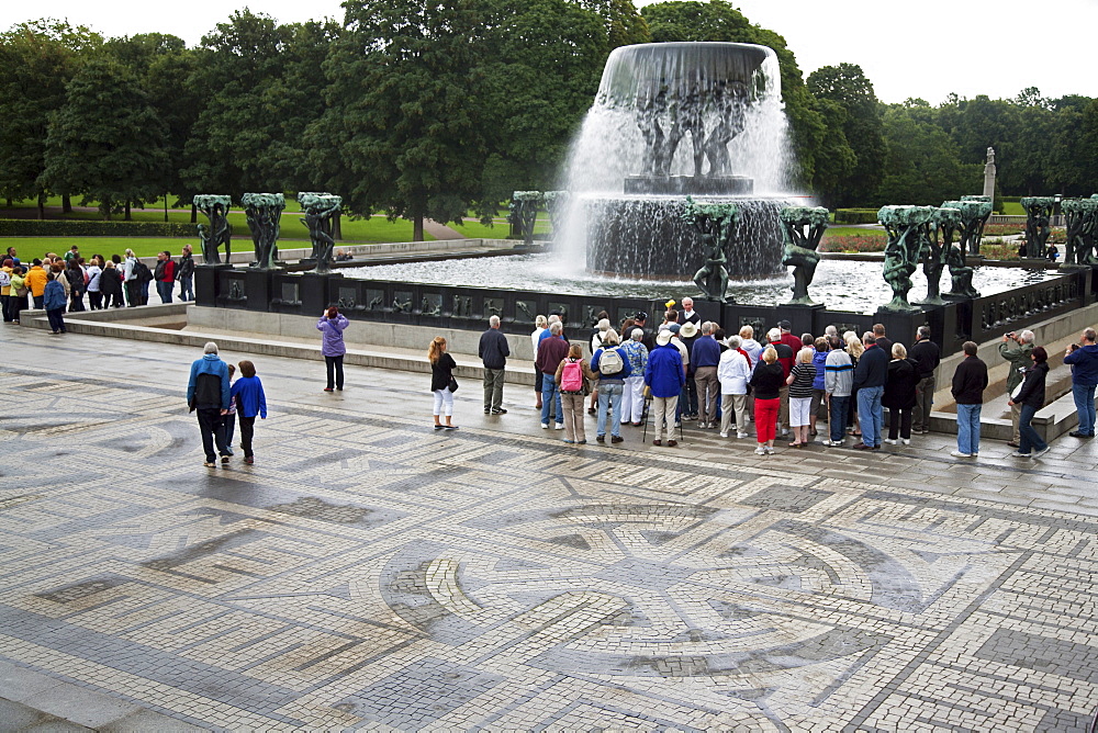 Tourists near fountain at the Vigeland Sculpture Arrangement designed by Gustav Vigeland, Frogner Park (Vigeland's Park), Oslo, Norway, Scandinavia, Europe