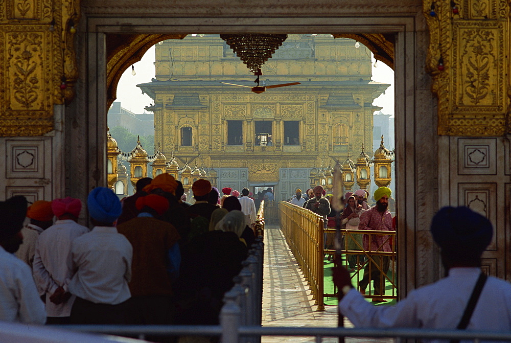 Sikhs at the entrance to the Golden Temple, crossing Guru's Bridge travelling in a clockwise direction, in Amritsar, Punjab, India, Asia