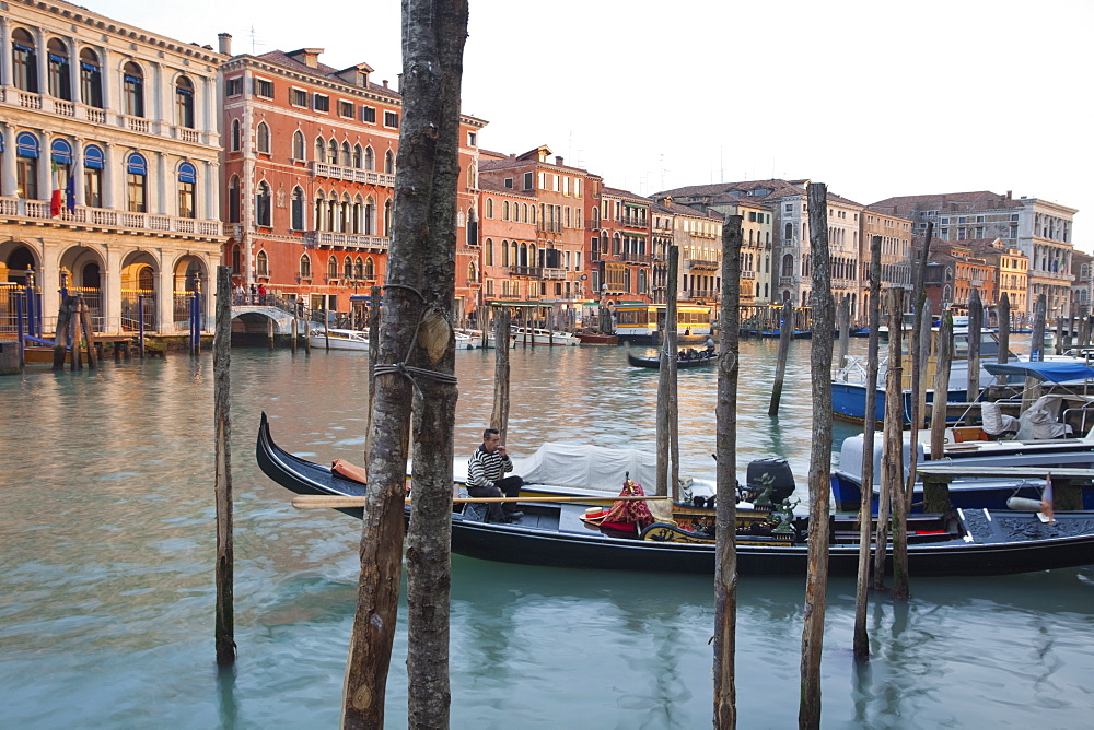 Evening light shines onto building lining the Grand Canal by the Rialto Bridge, Venice, UNESCO World Heritage Site, Veneto, Italy, Europe