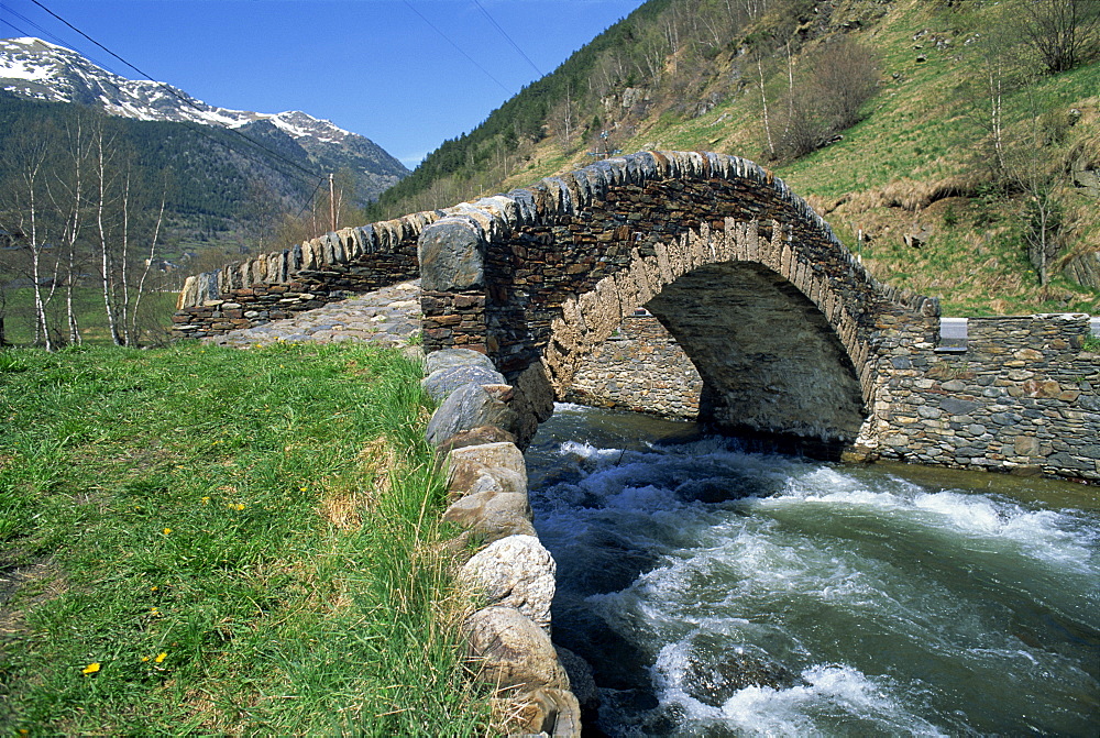 Ancient stone bridge over a river in the La Malana district in the Pyrenees in Andorra, Europe