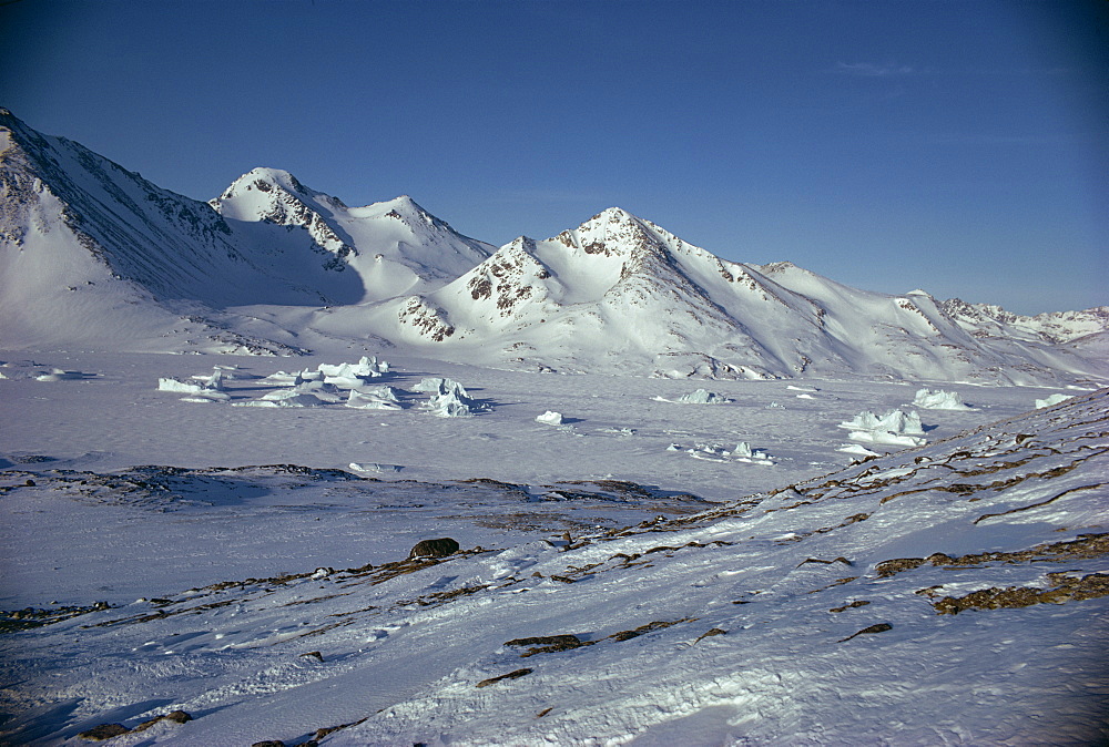 Rocky landscape and mountains covered in snow in Greenland, Polar Regions