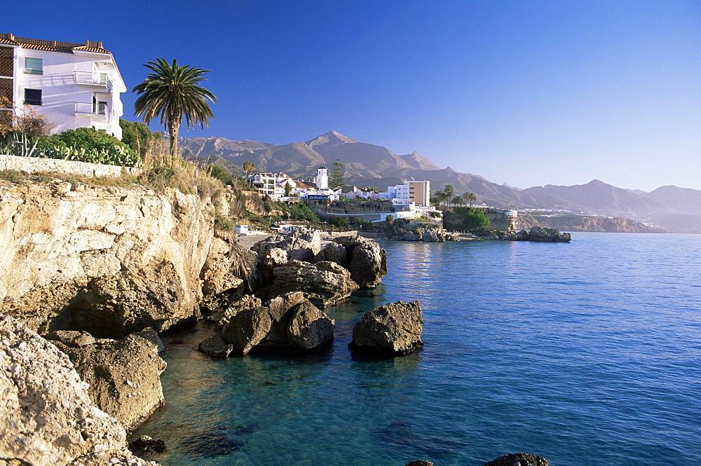 View along rocky coast to town and mountains, Nerja, Malaga area, Costa del Sol, Andalucia, Spain, Mediterranean, Europe