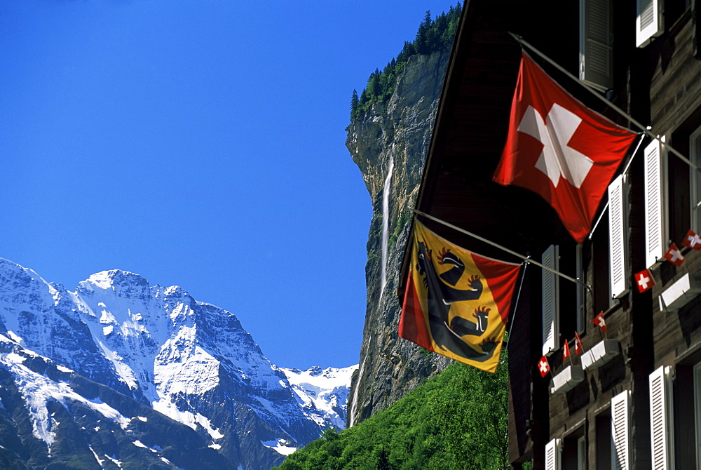 Snow-capped peaks, the Staubbach falls and flags of Bern and Switzerland, Lauterbrunnen, Bern, Switzerland, Europe