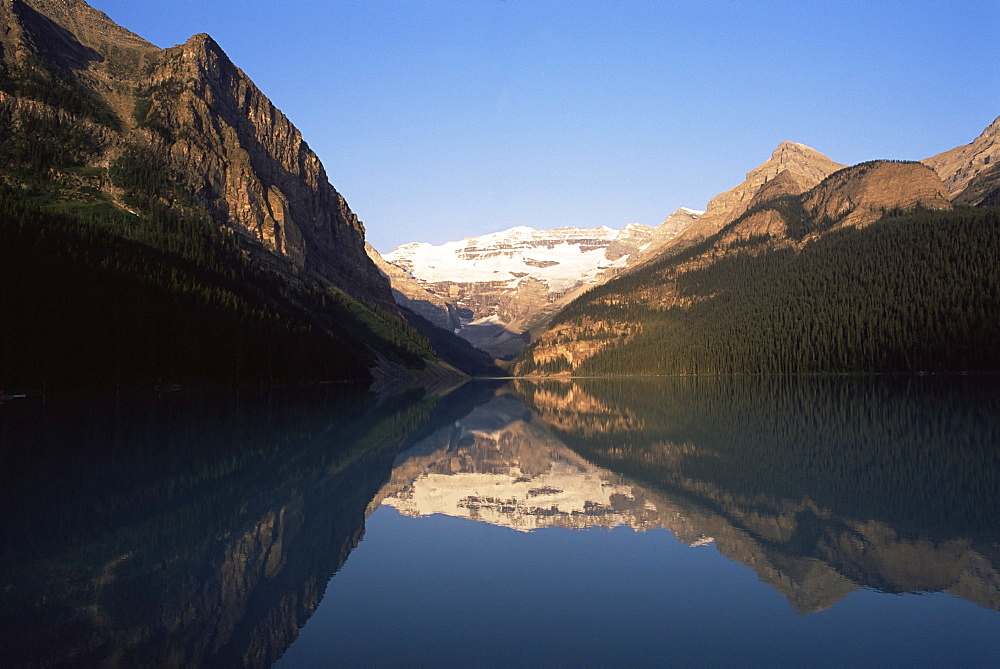 View to Mount Victoria across the still waters of Lake Louise, at sunrise in summer, Banff National Park, UNESCO World Heritage Site, Alberta, Canada, North America