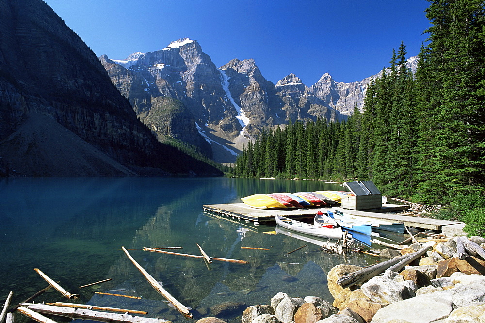 Canoes for hire on shore of Moraine Lake, with view to the Wenkchemna Peaks, Banff National Park, UNESCO World Heritage Site, Alberta, Canada, North America