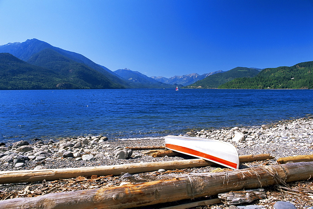 Upturned canoe on the rocky eastern shore of Slocan Lake, New Denver, British Columbia (B.C.), Canada, North America