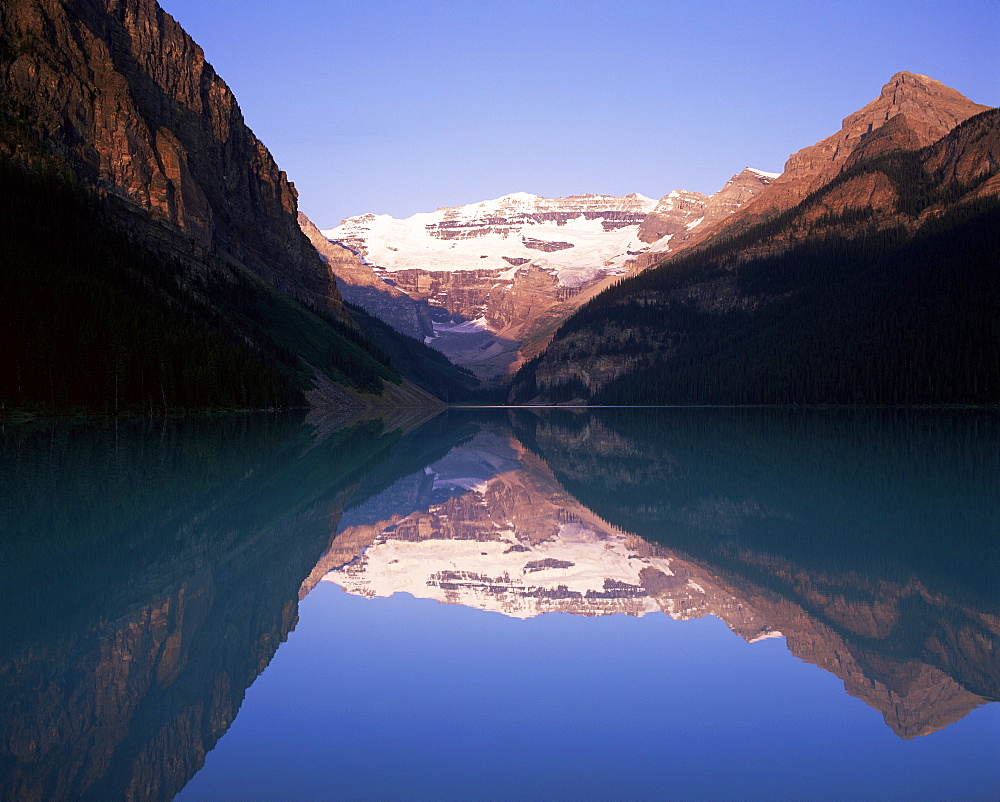 View to Mount Victoria across the still waters of Lake Louise, at sunrise, Banff National Park, UNESCO World Heritage Site, Alberta, Canada, North America