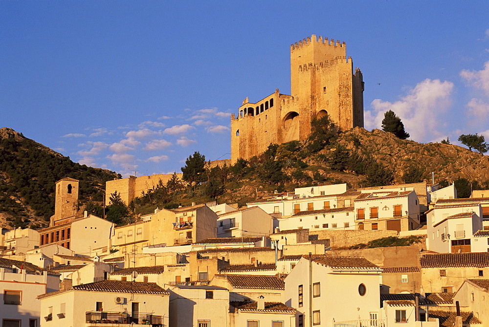 Whitewashed village houses dwarfed by the Castillo de los Fajardo at sunrise, Velez Blanco, Almeria, Andalusia (Andalucia), Spain, Europe