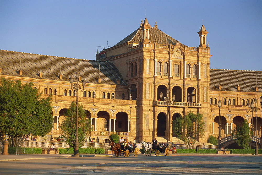 Horse-drawn carraiges and the Palacio Espanol at sunset, Plaza de Espana, Parque de Maria Luisa, Seville, Andalucia (Andalusia), Spain, Europe