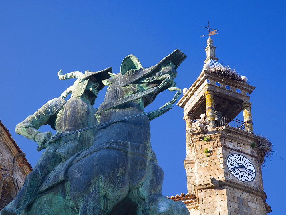 Equestrian statue of Francisco Pizarro in the Plaza Mayor, clock-tower of the Iglesia de San Martin beyond, Trujillo, Caceres, Extremadura, Spain, Europe