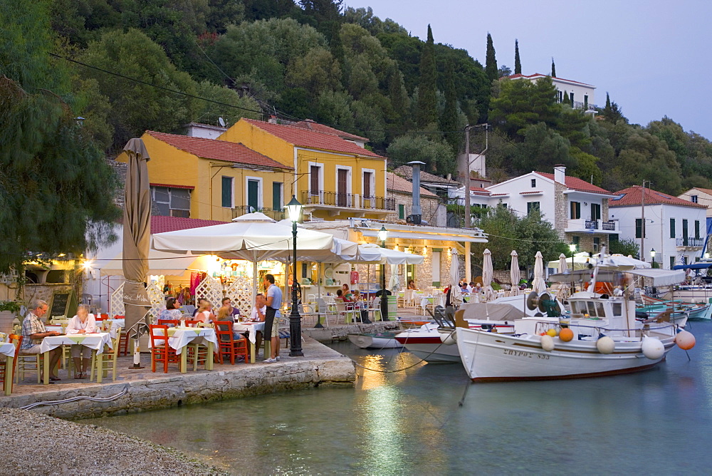 Typical waterfront taverna illuminated at dusk, Kioni, Ithaca (Ithaki), Ionian Islands, Greek Islands, Greece, Europe