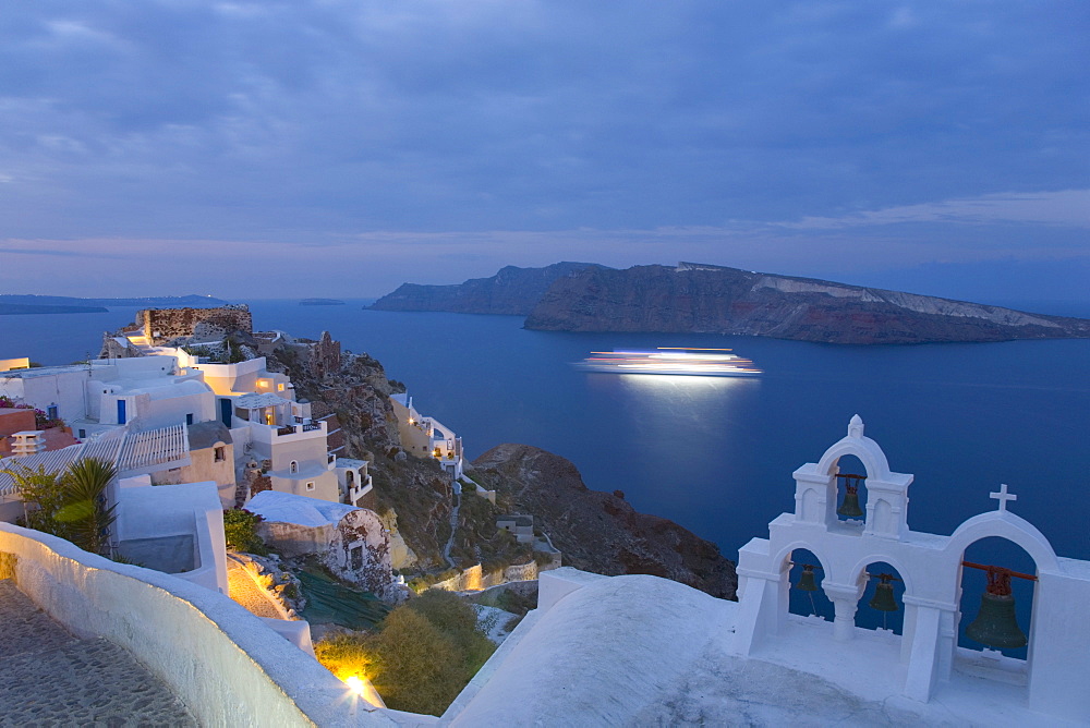 Illuminated cruise ship entering the caldera at dawn, Oia (Ia), Santorini (Thira) (Thera), Cyclades Islands, South Aegean, Greek Islands, Greece, Europe, 