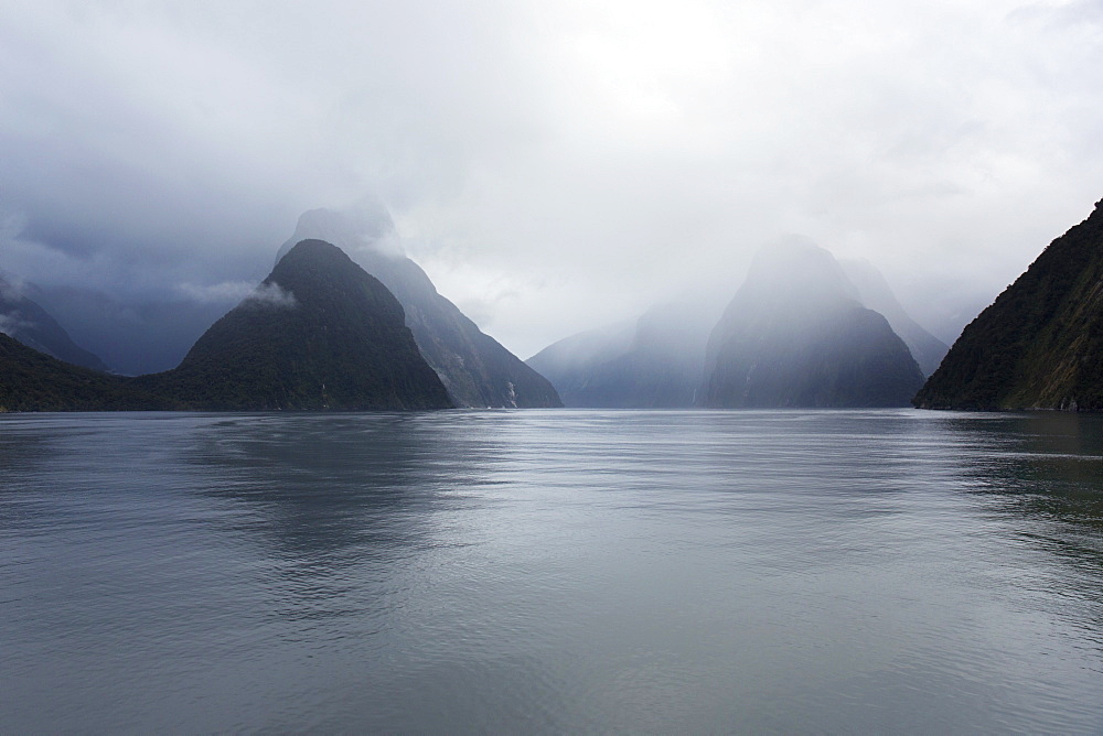 View down rainswept Milford Sound, mountains obscured by cloud, Milford Sound, Fiordland National Park, UNESCO World Heritage Site, Southland, South Island, New Zealand, Pacific