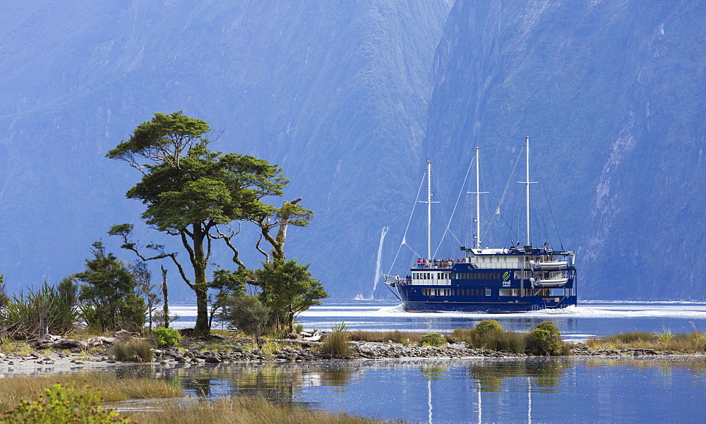 The Milford Mariner dwarfed by steep mountains, Milford Sound, Fiordland National Park, UNESCO World Heritage Site, Southland, South Island, New Zealand, Pacific