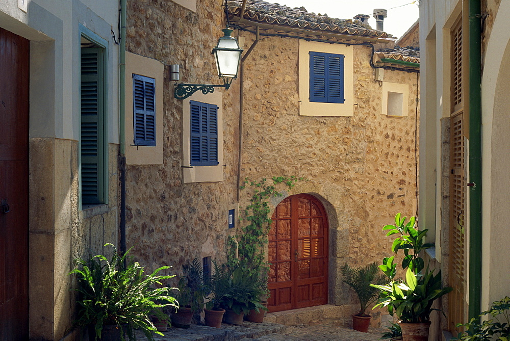 Plant pots and houses on a narrow street in the village of Biniaraix on Majorca, Balearic Islands, Spain, Europe