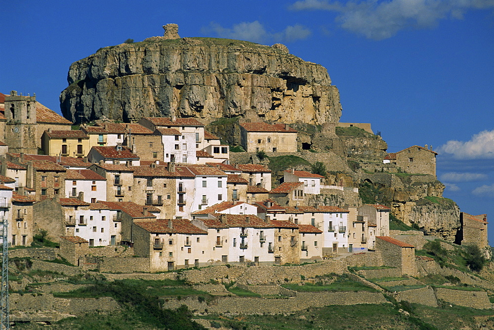 Houses overlook terraced fields, with rock cliff above the village of Ares del Maestre, Castellon, Valencia, Spain, Europe