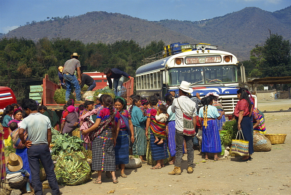 Men and women at the bus station during the Monday market at Antigua, Guatemala, Central America