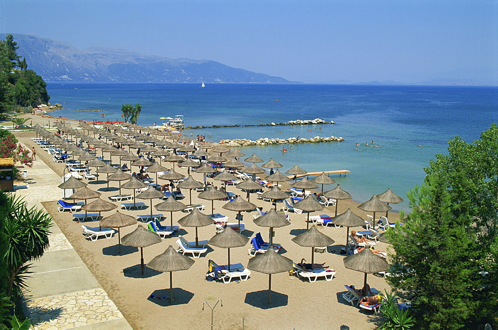 Beach umbrellas on coast near Dassia, on the island of Corfu, Ionian Islands, Greek Islands, Greece, Europe