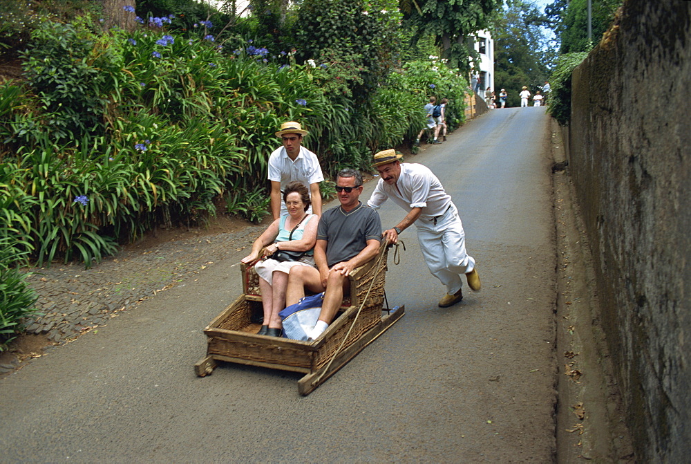 Tourists on toboggan riding down the hill at Monte, Madeira, Portugal, Europe