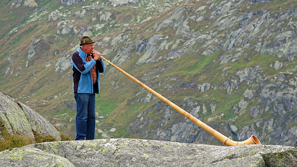 Alpenhorn player at Gotthard Pass, Canton of Uri, Switzerland, Europe