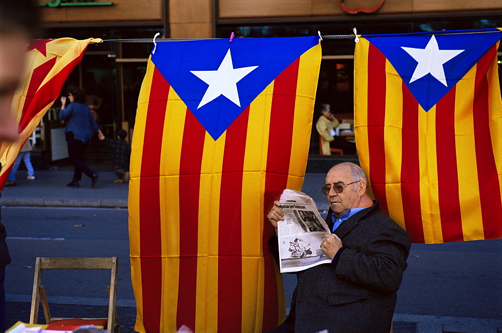 Reading the newspaper under the Catalan flag on La Rambla, Barcelona, Catalonia, Spain, Europe