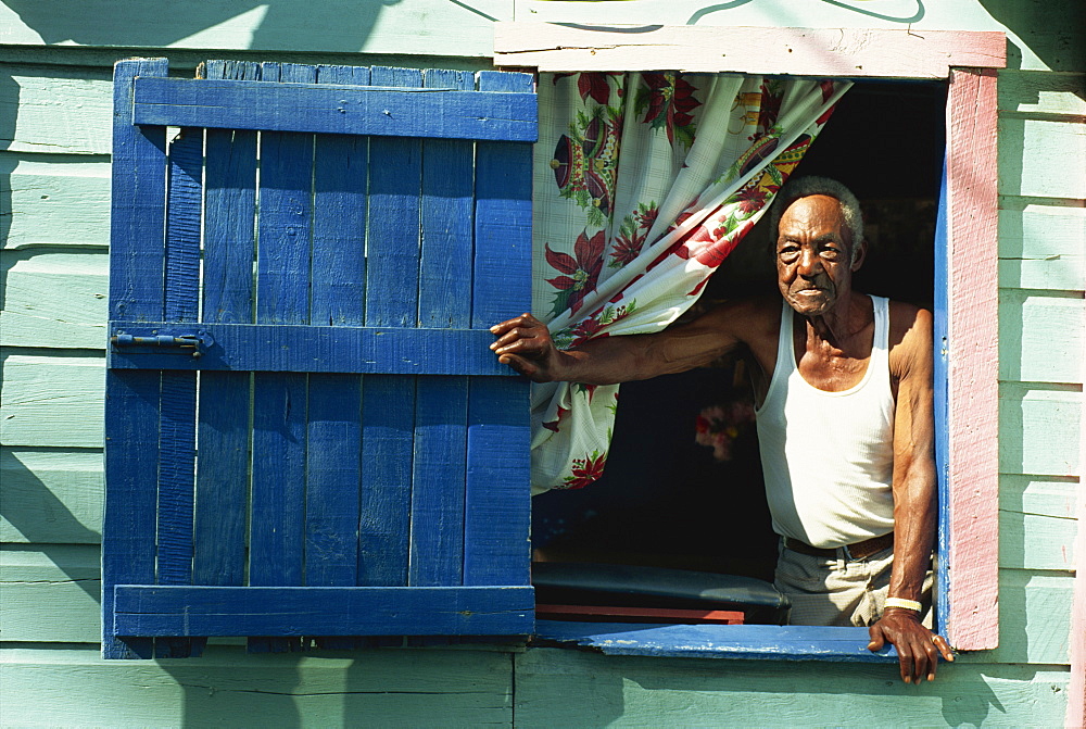 Portrait of elderly man at window of house, Gales Point, Belize, Central America