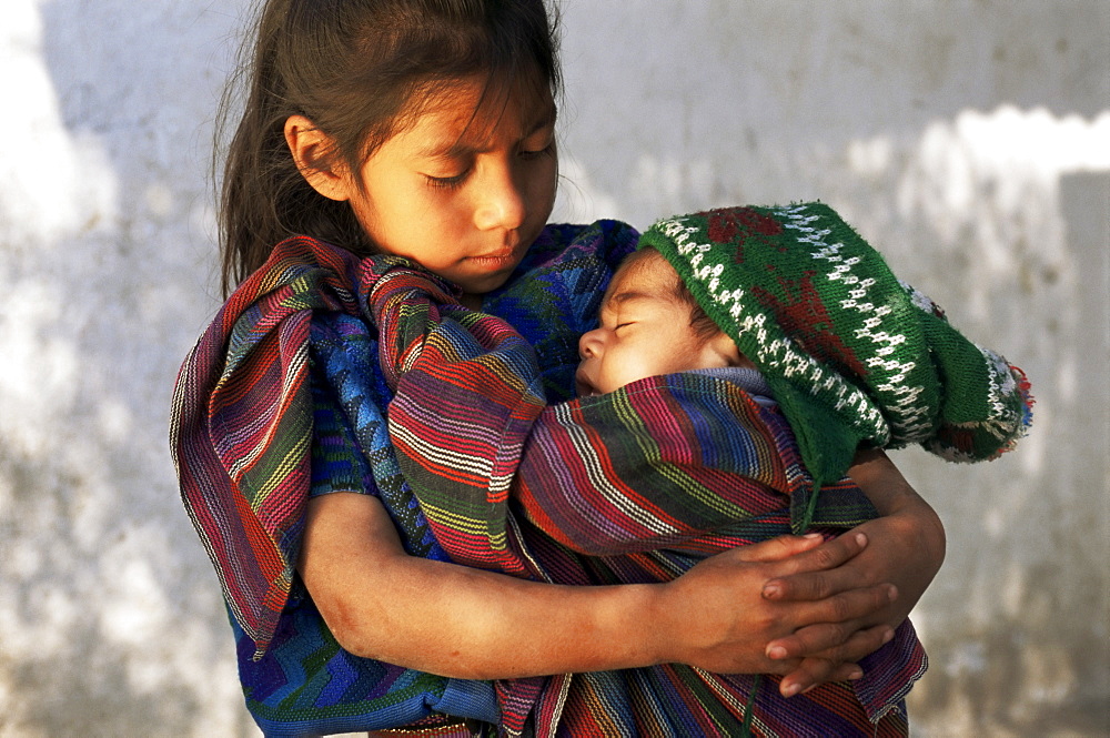 Little girl holding sleeping baby, Santa Catarina Palopo, Guatemala, Central America