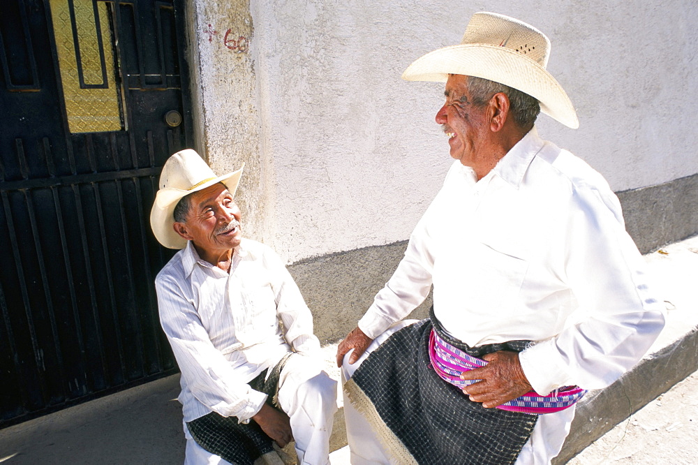 Old men in traditional dress chatting, Tecpan, Guatemala, Central America