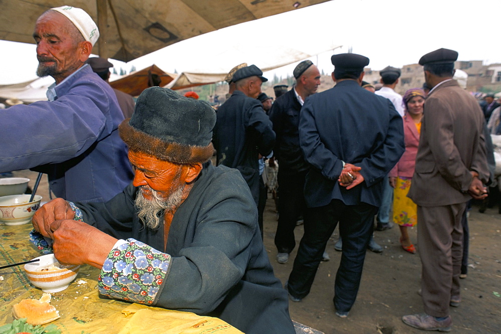 Old Uighur man at food stall, Sunday market, Kashi, Xinjiang, China, Asia