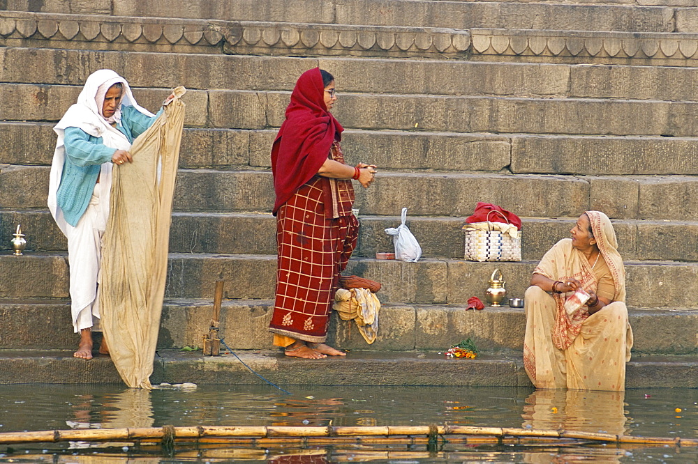 Women washing and gossiping by steps to River Ganges, Varanasi (Benares), Uttar Pradesh, India, Asia