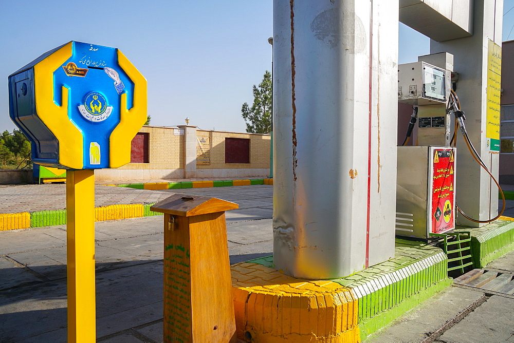 Two dominant themes of religion and oil meet at the petrol station, where there is always a religious donation box, Varzaneh, Iran, Middle East