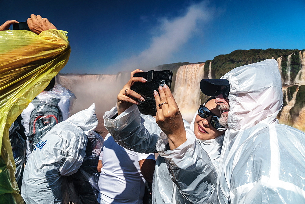 Selfie takers in plastic, Garganta del Diablo (Devil's Throat), Iguazu Falls, UNESCO World Heritage Site, Iguazu, Brazil, South America