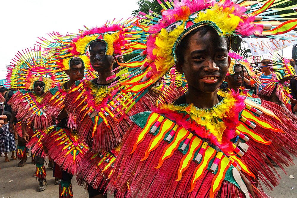 Four participants in flamboyant coloured dress marching at the annual Ati-Atihan Festival, Kalibo Island, Philippines, Southeast Asia, Asia