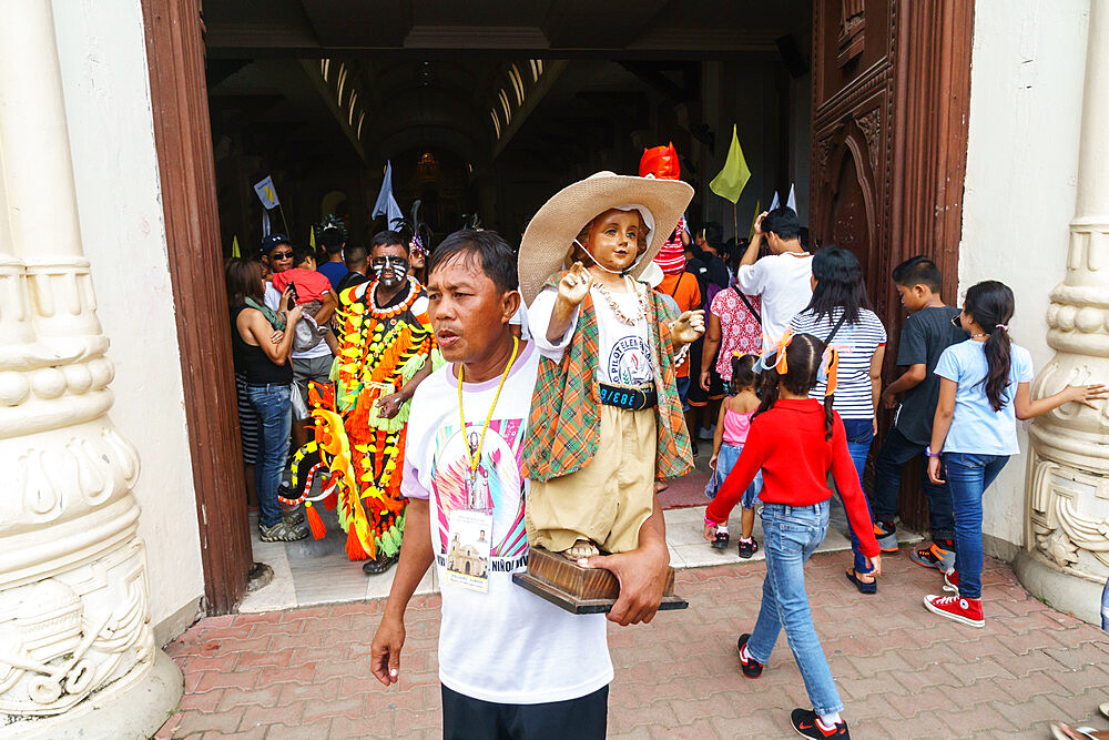 Worshipper at the door of the Cathedral with Baby Jesus statuette at the annual Ati-Atihan Festival, Kalibo Island, Philippines, Southeast Asia, Asia