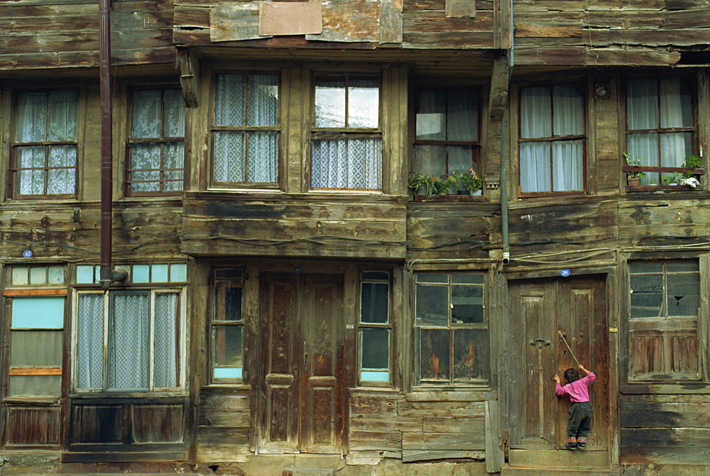 Small child and wooden house, Heybeliada, Princes Islands (Kizil Adalar), Turkey, Eurasia