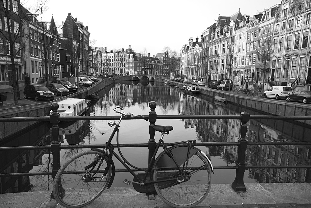 Black and white imge of an old bicycle by the Singel canal, Amsterdam, Netherlands, Europe