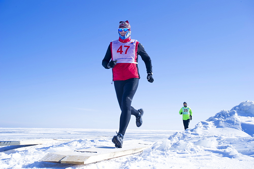 Runners in the 10th Baikal Ice Marathon, run on the frozen surface of the world's largest fresh water lake on 1st March 2014, Siberia, Irkutsk Oblast, Russia, Eurasia