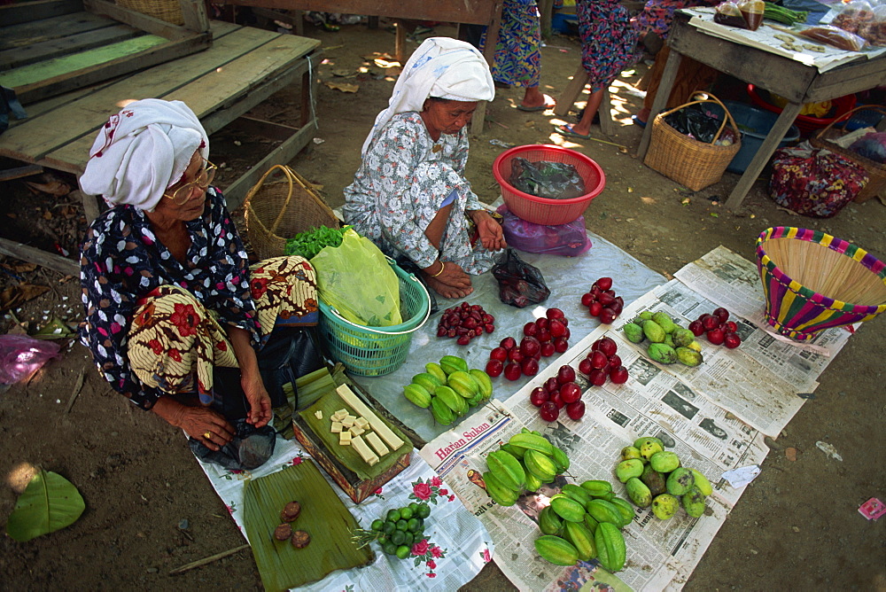 Women selling local produce including star fruit, plums and beeswax at Kota Belud weekly Tamu or market in Sabah, Malaysia, Borneo, Southeast Asia, Asia