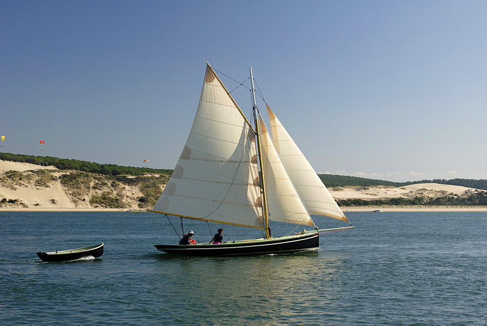 Od gaff rigged sailing yacht and dinghy, sailing along Dune du Pyla, Bay of Arcachon, Gironde, Aquitaine, France, Europe