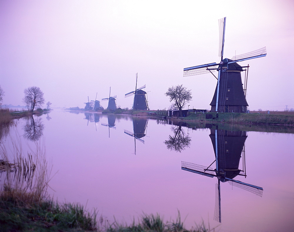 Windmills in early morning mist, Kinderdijk, UNESCO World Heritage Site, Holland, Europe