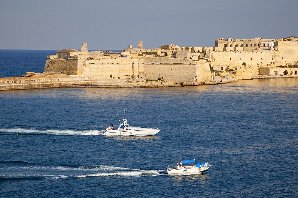 Fort Ricasoli from Valletta, with yacht and water taxi passing, Malta, Mediterranean, Europe