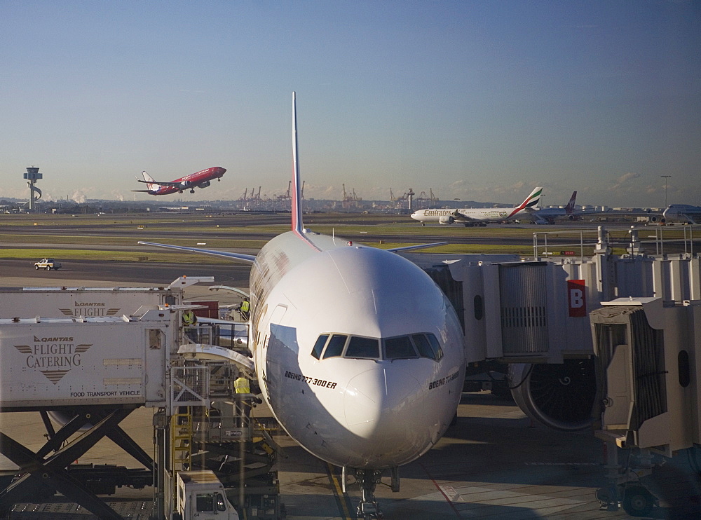 Boeing 777-300 ER jet airliner of Emirates Airline at gate, Emirates and Virgin Blue planes behind, Sydney Airport, Australia, Pacific