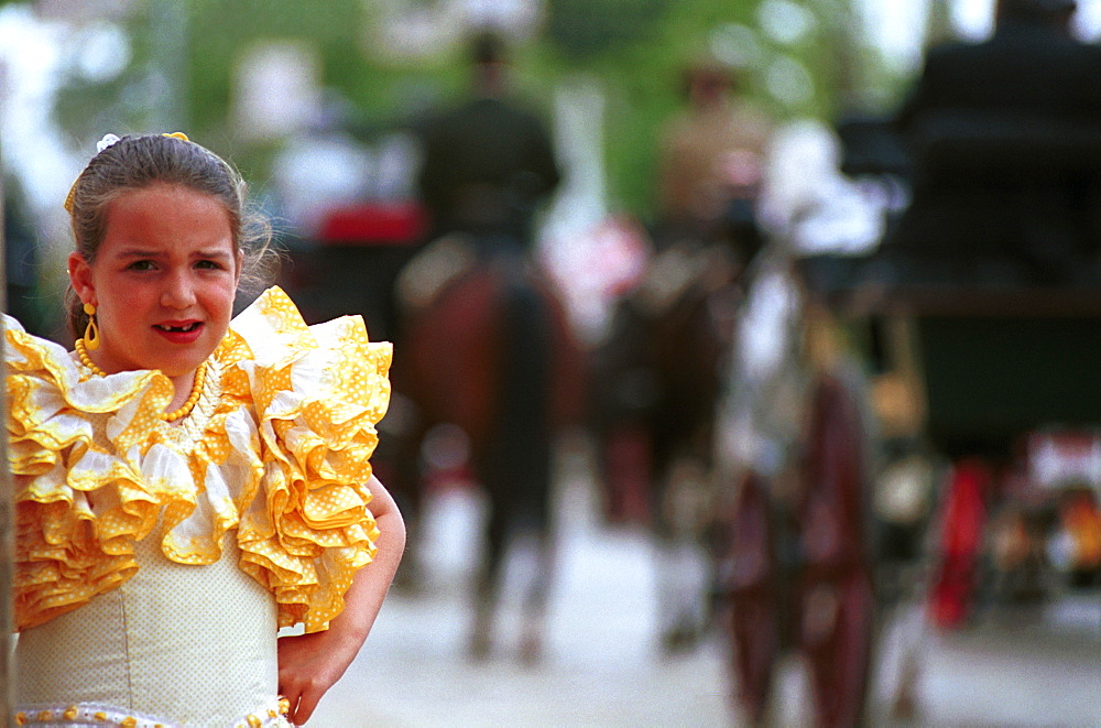 Seville - Spain - The Feria de Abril - Seville Fair - A girl in traditional costume watching the carriage parade 