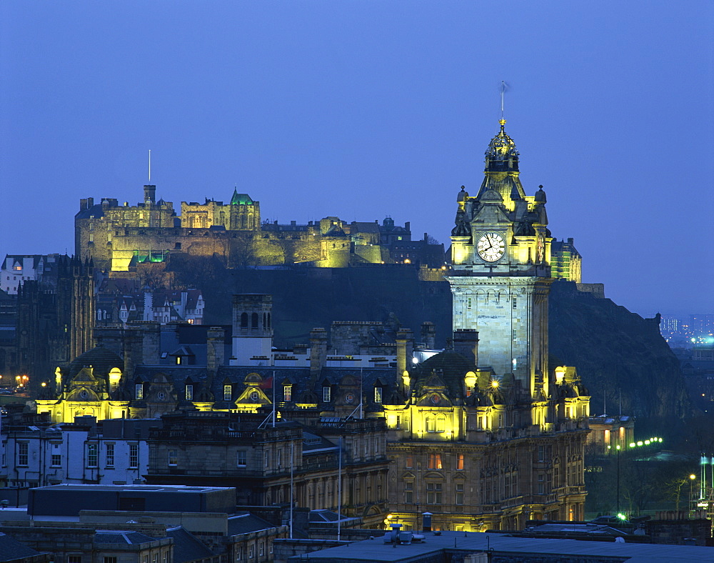 Edinburgh Castle and the Waverley Hotel clock tower illuminated at dusk, Edinburgh, Lothian, Scotland, United Kingdom, Europe