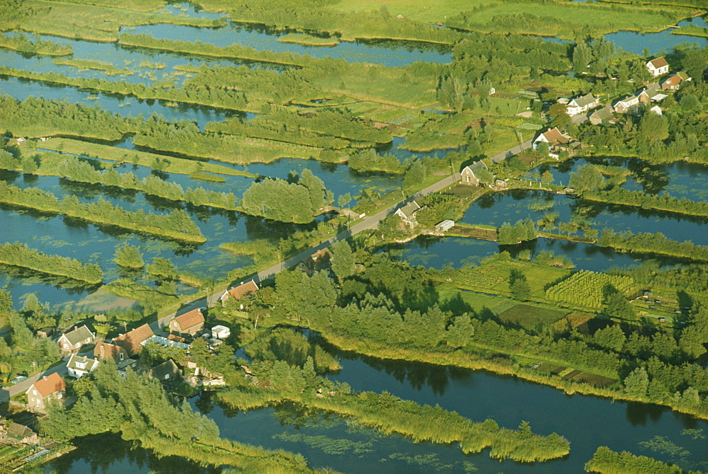 Aerial of a road across a landscape of water and tree lined embankments between Haquet and Utrecht in the Netherlands, Europe