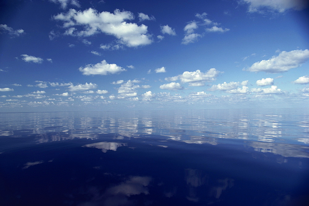 Reflections of white clouds and blue sky in the water of the Indian Ocean in the Maldives, Indian Ocean, Asia